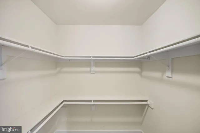 a view of walk in closet with wooden floor