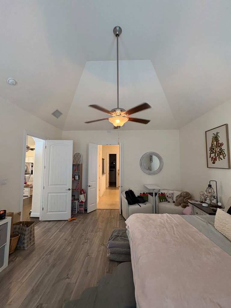 3812 Alpine Rdg Cove Leander, TX 78641 - Photo 26 of 37 A well-lit bedroom with vaulted ceilings and attractive wood flooring, creating an inviting personal retreat.