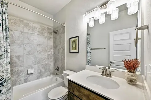 a bathroom with a granite countertop sink toilet and shower
