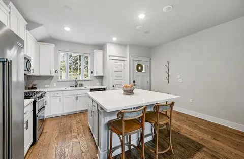 a kitchen with a table chairs refrigerator and microwave
