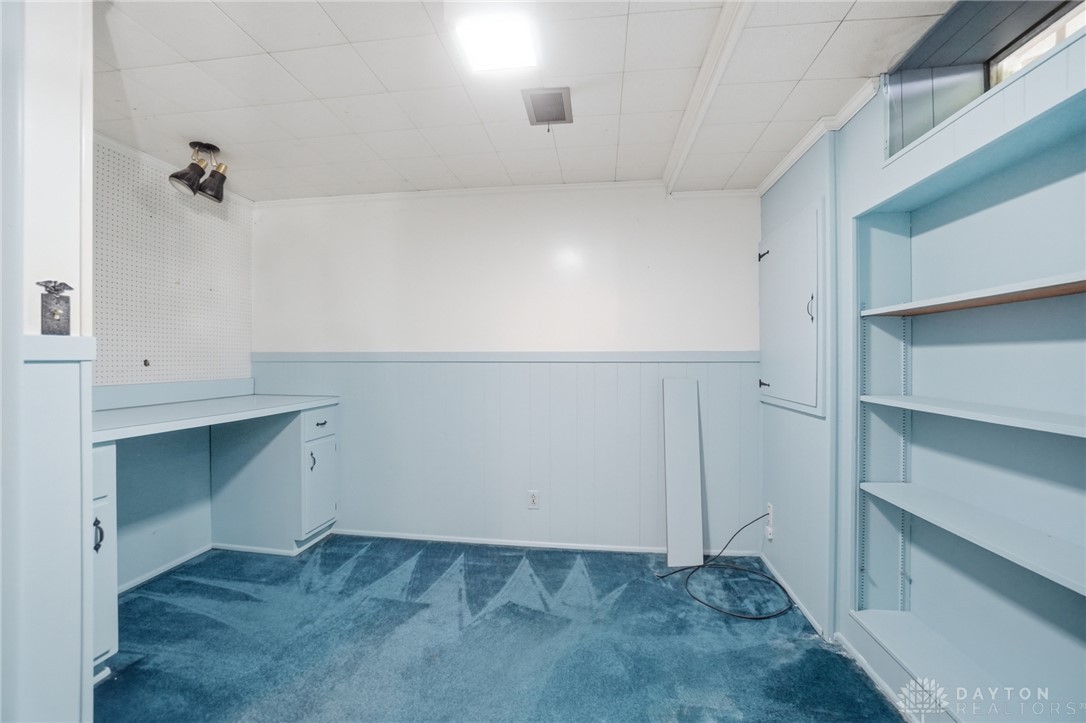 6119 Flemington Road Dayton, OH 45459 - Photo 48 of 76 This versatile basement room features built-in shelving and desk, perfect for an office or recreation space.