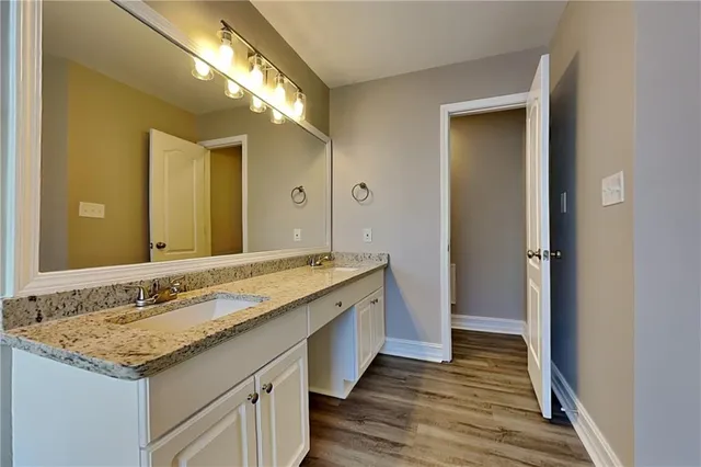 a bathroom with a granite countertop sink and a mirror