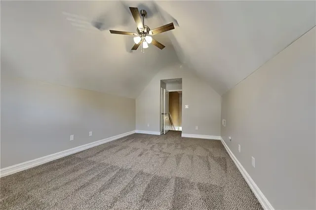a view of an empty room with a chandelier fan