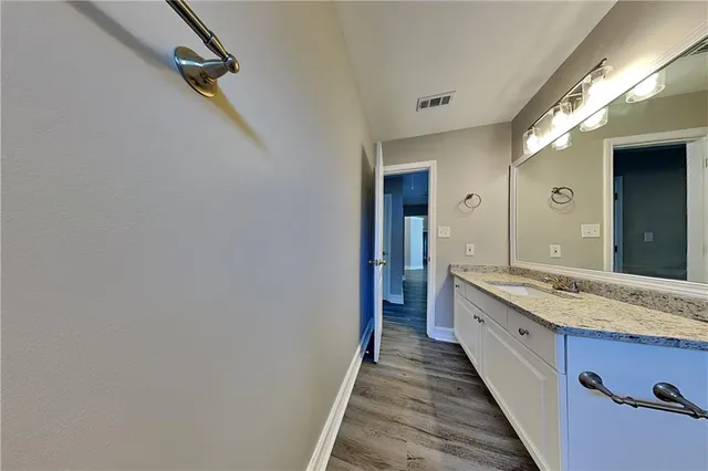 a bathroom with a granite countertop sink and a mirror
