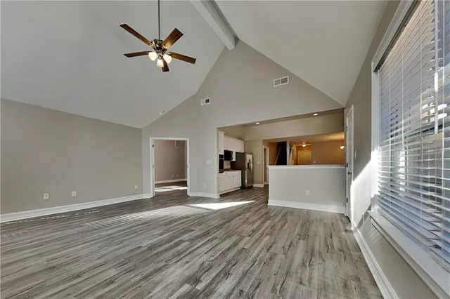 a view of a livingroom with a ceiling fan and wooden floor
