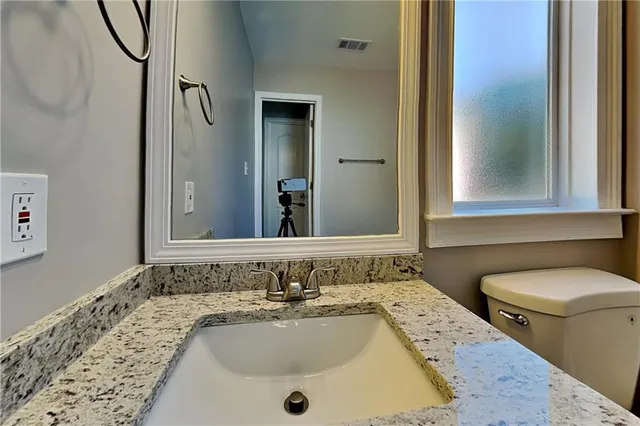 a bathroom with a sink and mirror with toilet