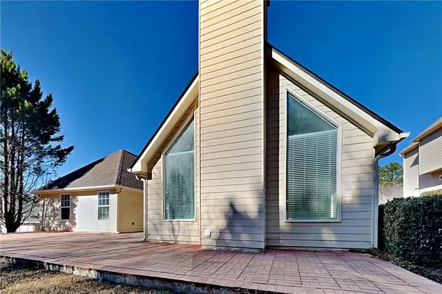 a view of house with backyard and sitting area