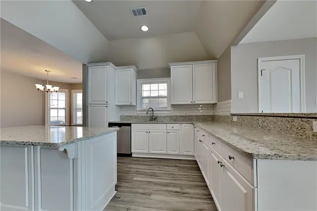 a kitchen with granite countertop sink stainless steel appliances and cabinets
