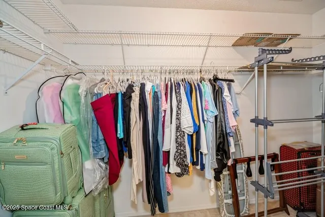 a view of walk in closet with clothes