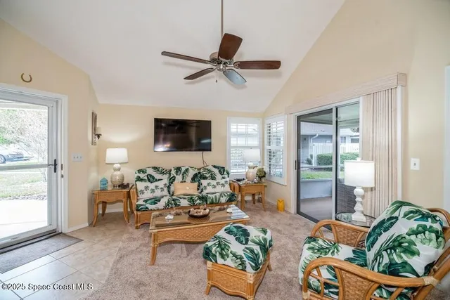a living room with patio furniture and a floor to ceiling window
