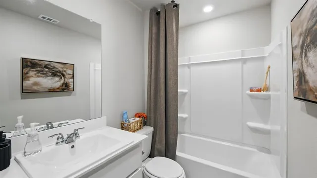 a bedroom with a bed and painting on the wall