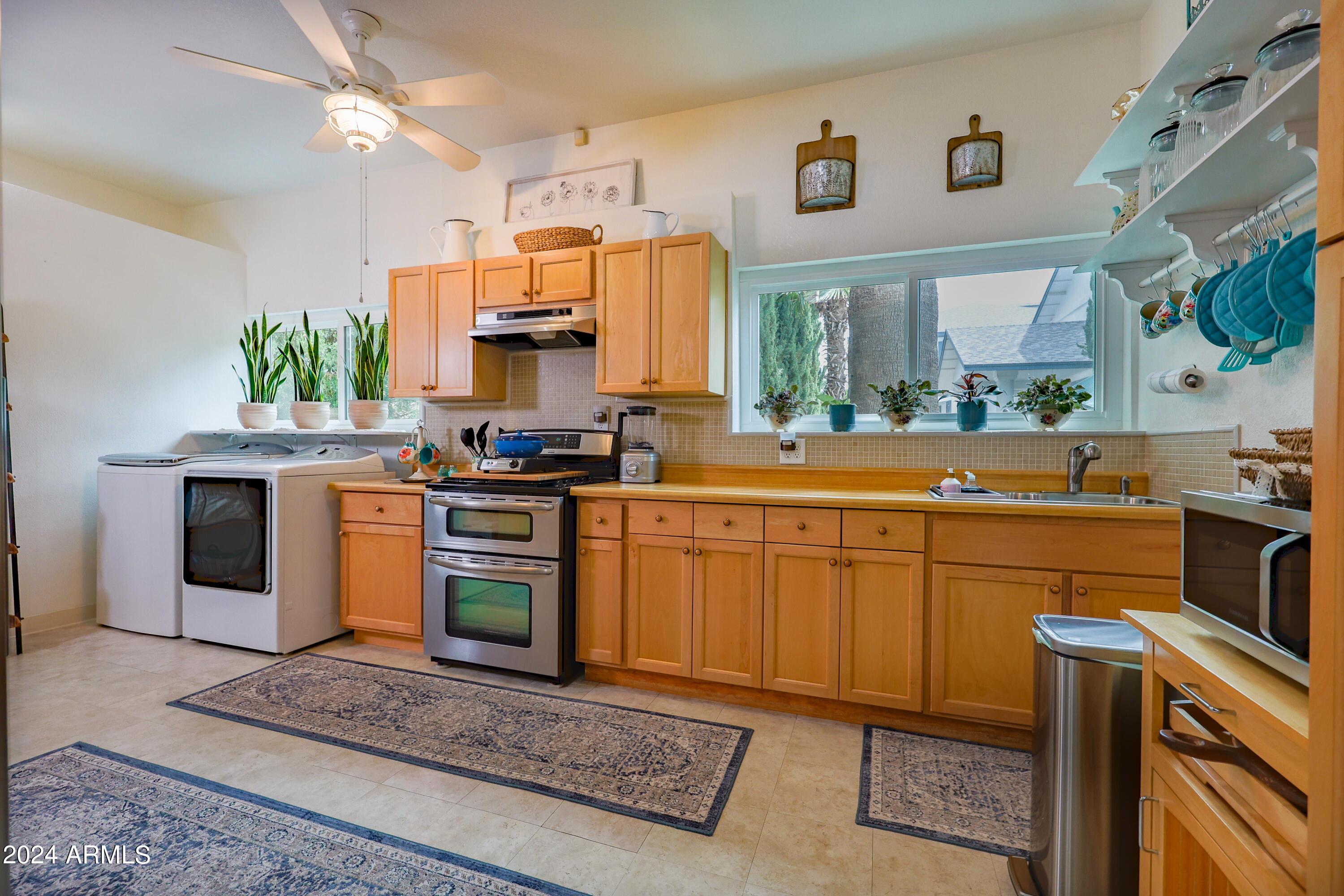 2204 North Maple Avenue Huachuca City, AZ 85616 - Photo 54 of 65 a kitchen with stainless steel appliances granite countertop a stove a sink and a microwave
