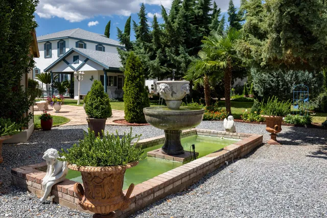 a couple of palm trees sitting in a yard with swimming pool