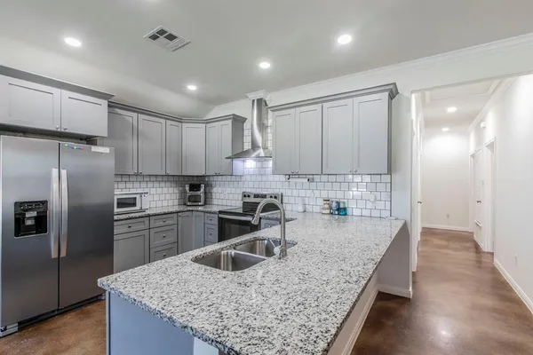 a kitchen with stainless steel appliances granite countertop a sink stove and refrigerator