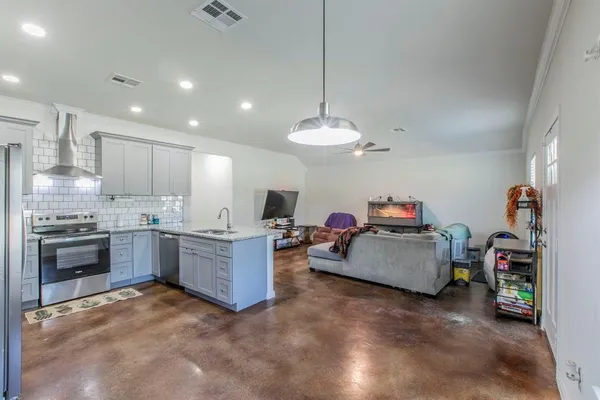 a kitchen that has a lot of cabinets and stainless steel appliances