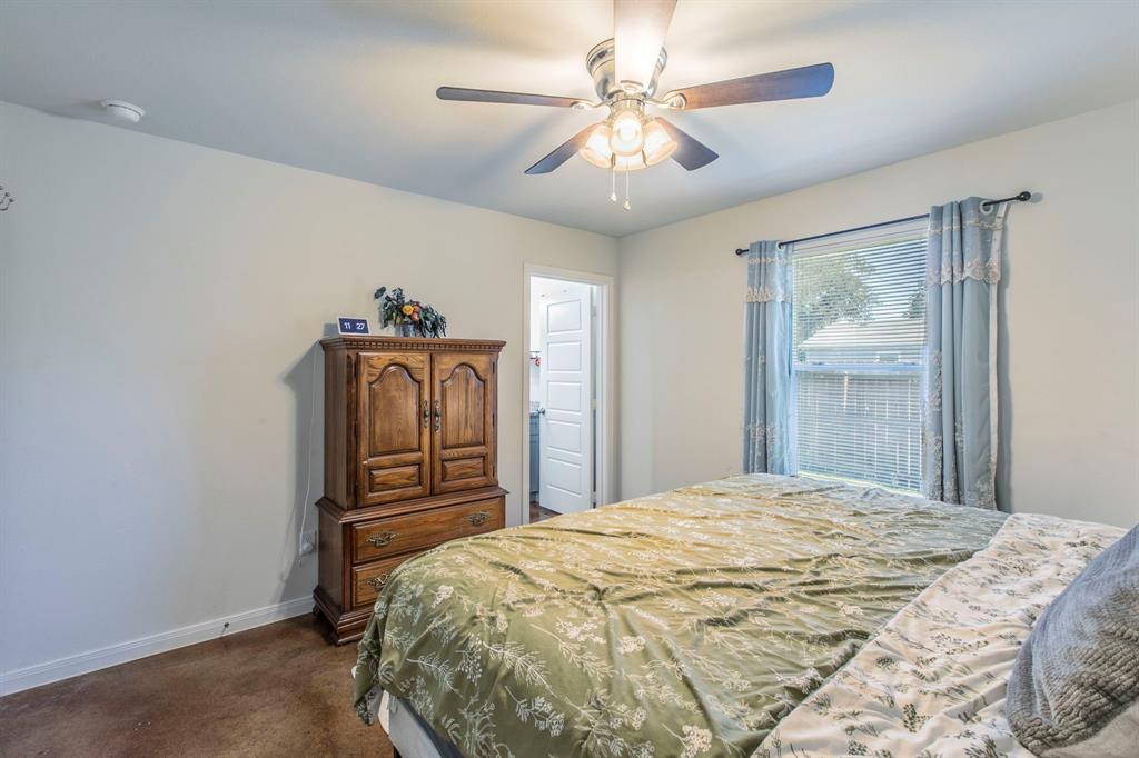 625 Delano Street Waco, TX 76704 - Photo 9 of 18 a bedroom with a bed and a chandelier