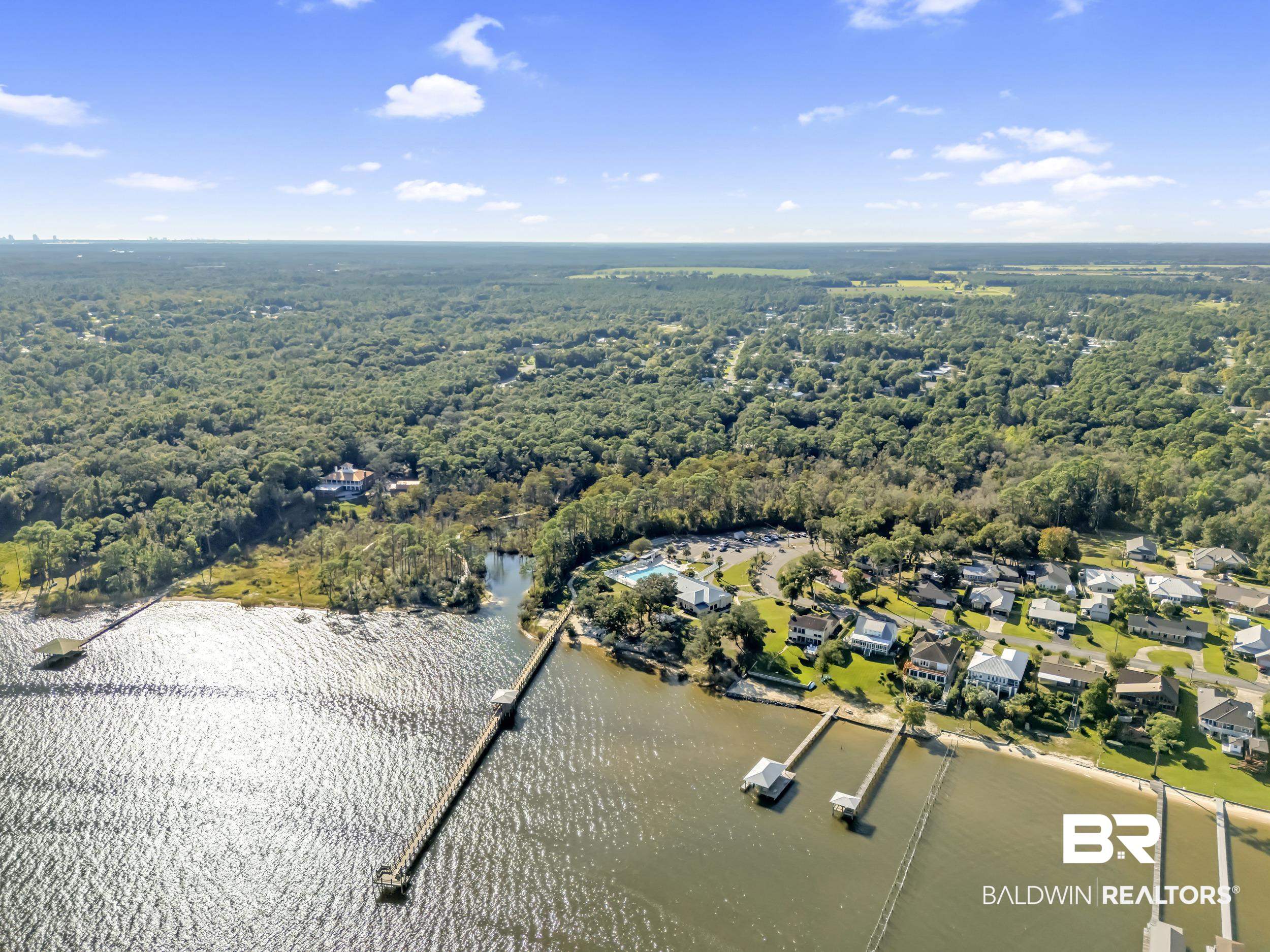 182 Defuniak Loop Lillian, AL 36549 - Photo 20 of 21 Aerial perspective of suburban area with a heavily wooded area and a large body of water