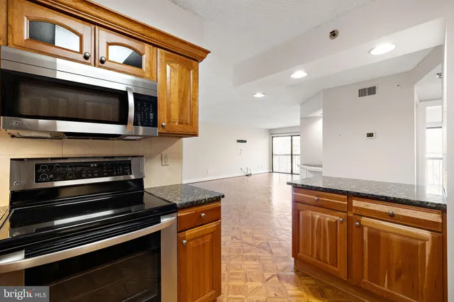 a kitchen with stainless steel appliances a stove and cabinets