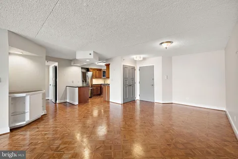 a view of a kitchen with a refrigerator and a stove top oven