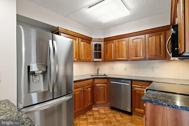 a kitchen with stainless steel appliances granite countertop a refrigerator and a sink