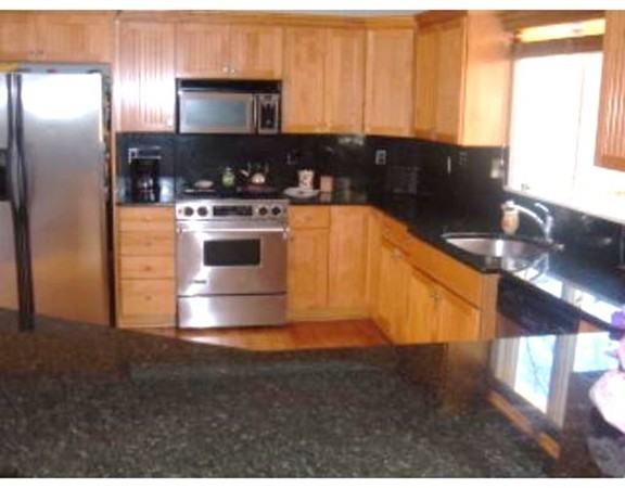 216 Rangeway Road, Unit 144 Billerica, MA 01862 - Photo 4 of 25 a kitchen with stainless steel appliances granite countertop a stove a sink and a microwave