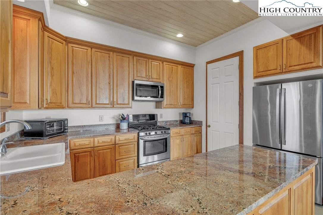 933 Thunder Ridge Lane Lenoir, NC 28645 - Photo 14 of 45 a kitchen with stainless steel appliances granite countertop a stove a sink a microwave and refrigerator