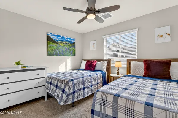 a bedroom with two beds and painting on the wall