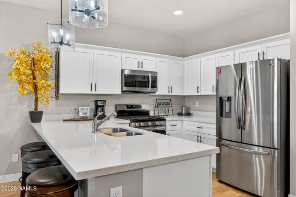 a kitchen with kitchen island a white counter top space cabinets and stainless steel appliances