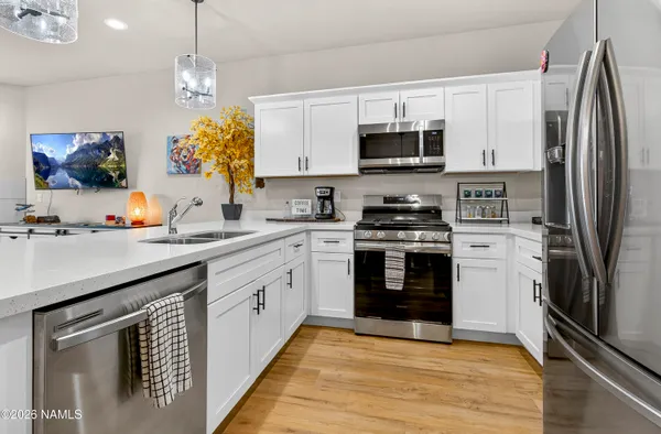 a kitchen with stainless steel appliances granite countertop a stove a sink and a refrigerator