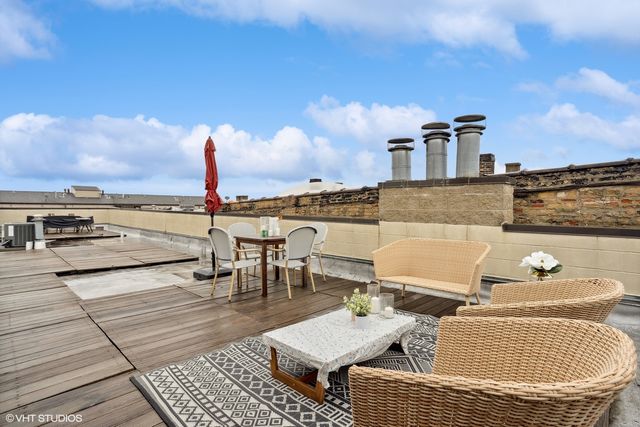 a view of a roof deck with dining table and chairs with wooden floor