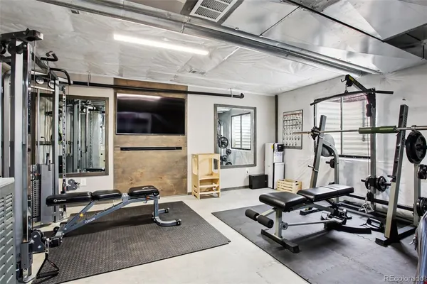a living room with furniture gym equipment and a large window