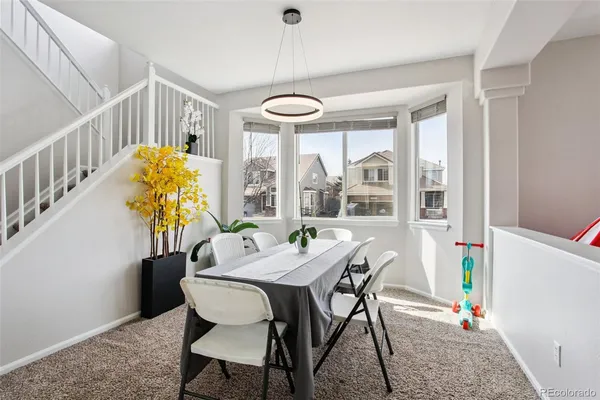 a dining room with furniture and a large window