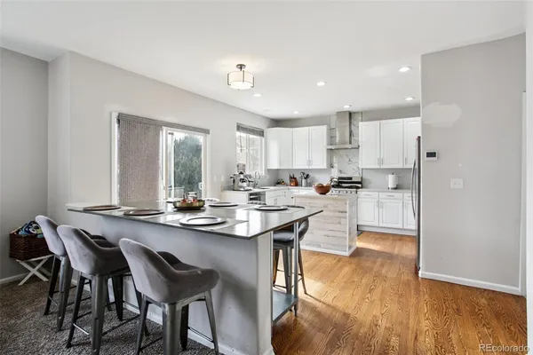 a kitchen with stainless steel appliances kitchen island a table and chairs in it