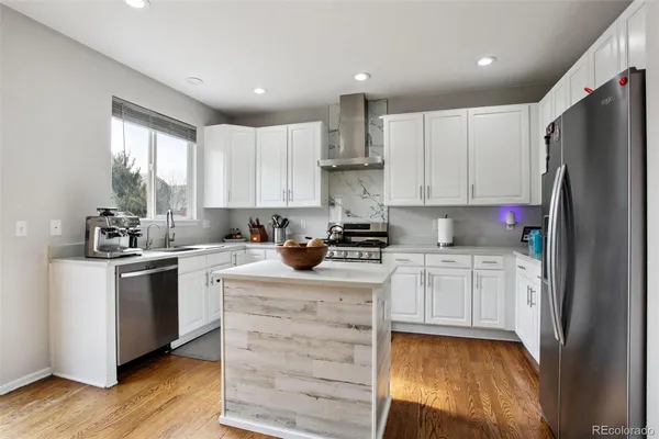 a kitchen with granite countertop white cabinets and white appliances