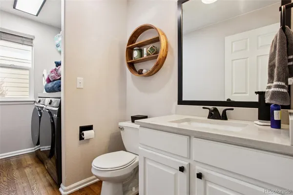 a bathroom with a toilet sink vanity and mirror