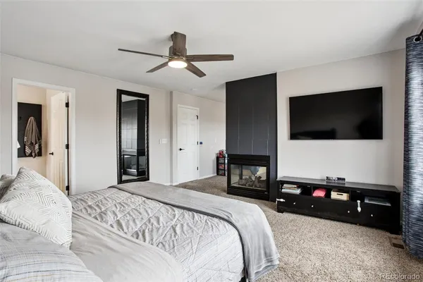 a bedroom with a bed and a flat tv screen on wall
