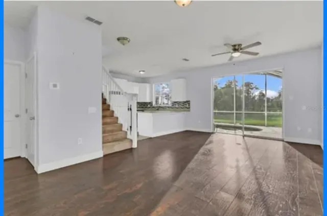 a view of a kitchen with wooden floor and a ceiling fan