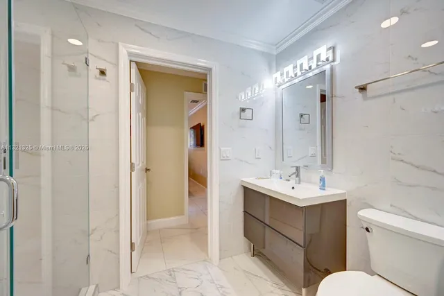 a bathroom with a sink toilet vanity and shower