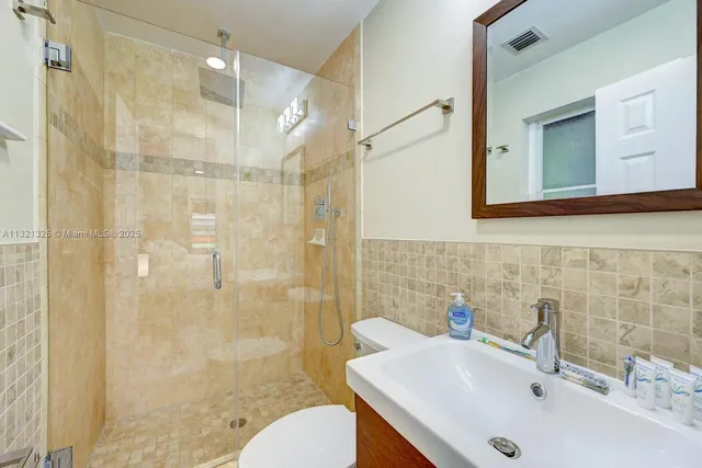 a bathroom with a sink mirror toilet and shower