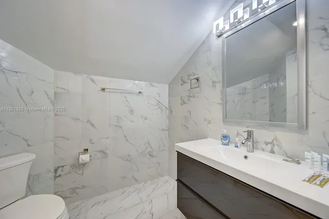 a bathroom with a sink toilet a mirror and shower