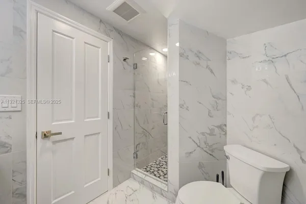 a bathroom with a toilet and shower