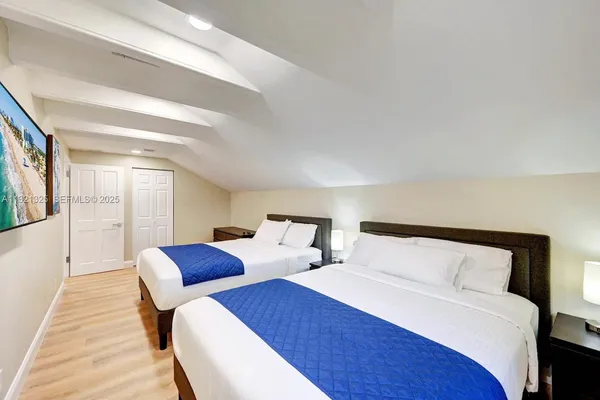 a bedroom with two beds and a night stand