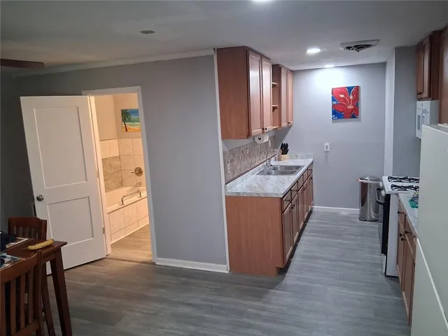 a kitchen with a refrigerator sink and wooden floor