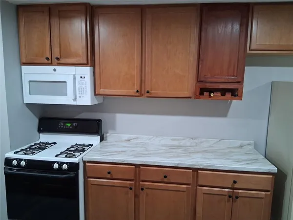 a kitchen with granite countertop cabinets and black appliances