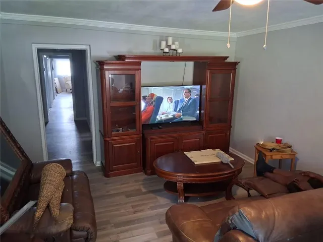 a living room with furniture and a wooden floor