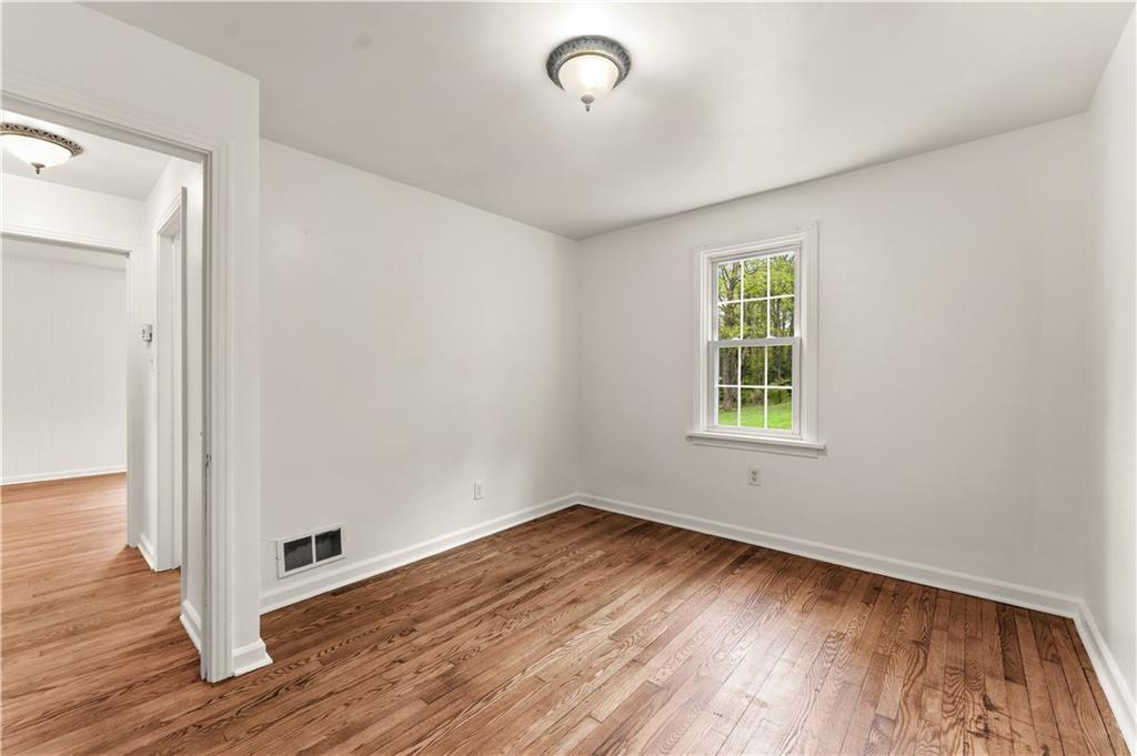 973 Blackhawk Road Beaver Falls, PA 15010 - Photo 19 of 36 an empty room with wooden floor and windows