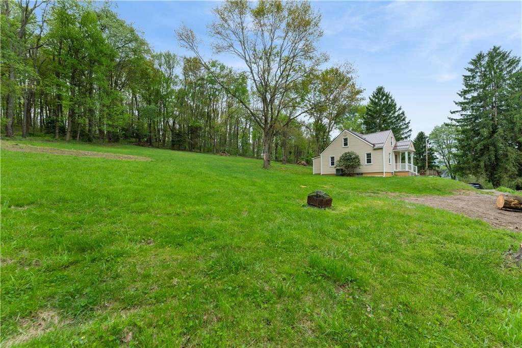 973 Blackhawk Road Beaver Falls, PA 15010 - Photo 30 of 36 a white house with a big yard and large trees