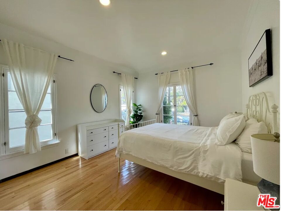 854 4th Street, Unit F Santa Monica, CA 90403 - Photo 10 of 13 a bedroom with a bed a mirror on dresser and a window