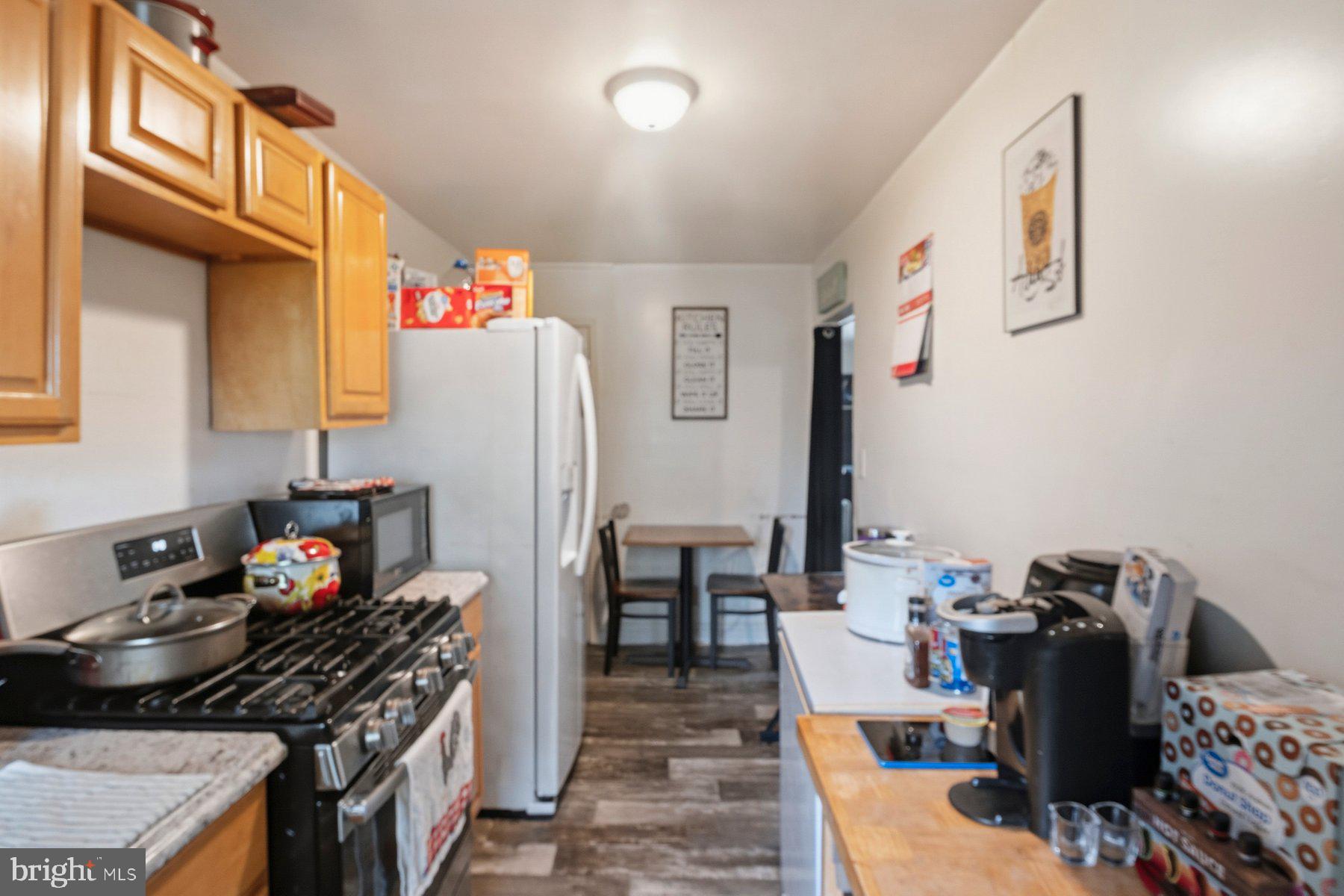 4931 Brookwood Road Baltimore, MD 21225 - Photo 11 of 25 a kitchen with stainless steel appliances granite countertop a stove refrigerator and a dining table
