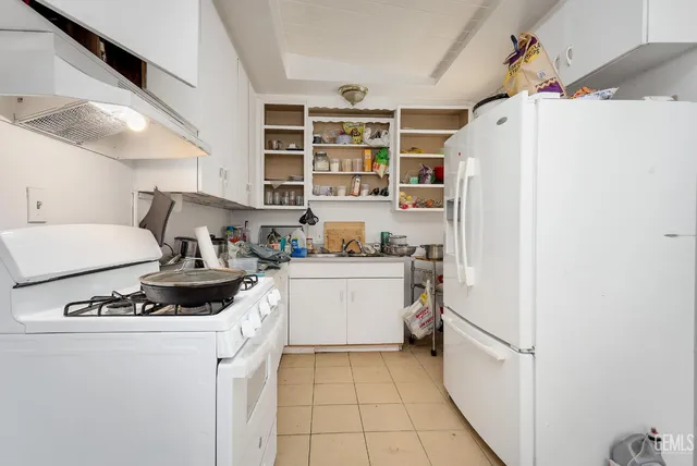 a kitchen with a refrigerator and white cabinets
